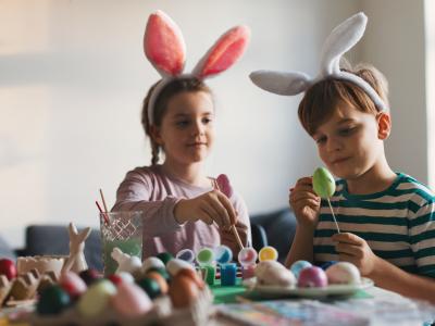 2 børn med kaninører maler påskeæg