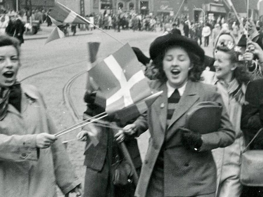Glade mennesker på det flagsmykkede Gammeltorv i København den 5. maj 1945. Af Frihedsmuseets fotoarkiv/Nationalmuseet.