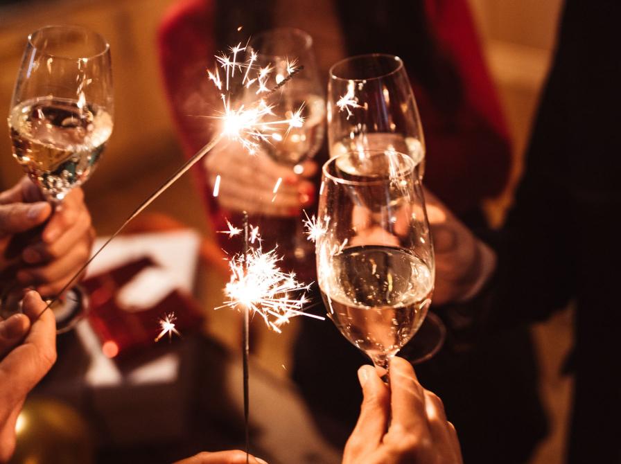 Folk skåler nytåret ind med champagne.