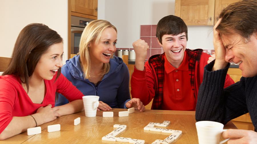 Kvinde, mand og to teenager spiller brætspil