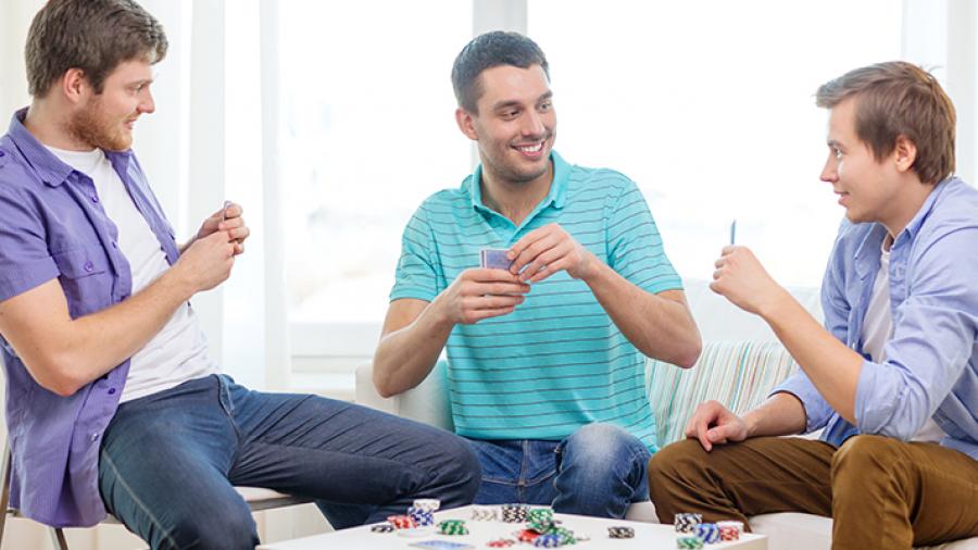 Tre unge mænd spiller brætspil